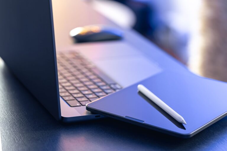 Close up of digital tablet stylus pen and laptop on the desktop