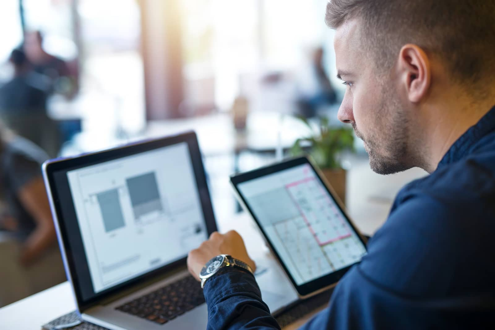 Business man looking and analyzing projects on his laptop computer and tablet